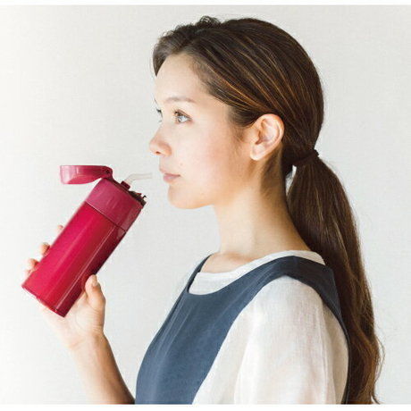 サーモスのストローマグで飲み物を飲む女性