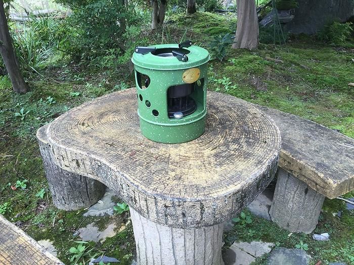 木のテーブルの上に置いてあるだるまストーブ
