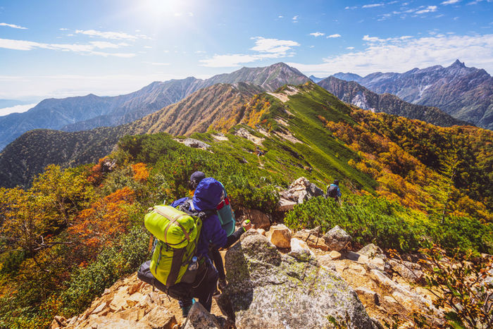 アウトドアバッグを背負って登山している人の様子