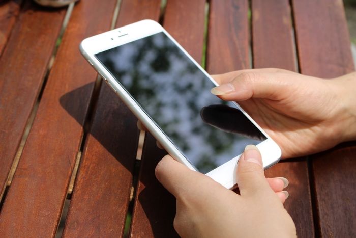 スマホをいじる手