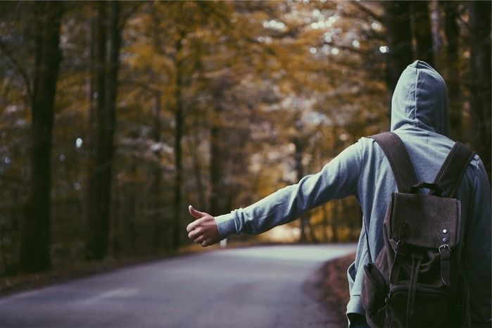 パーカーを着て山道に立っている男性の写真