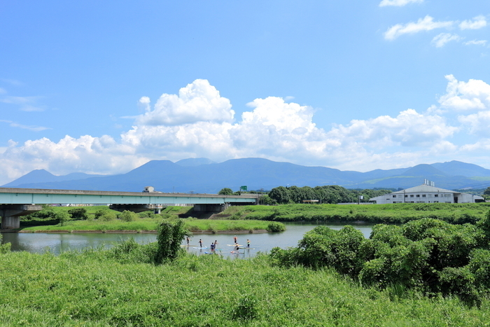緑に囲まれた湖でサップをする人たち