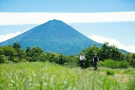 富士山をバックにサイクリングを楽しむ人
