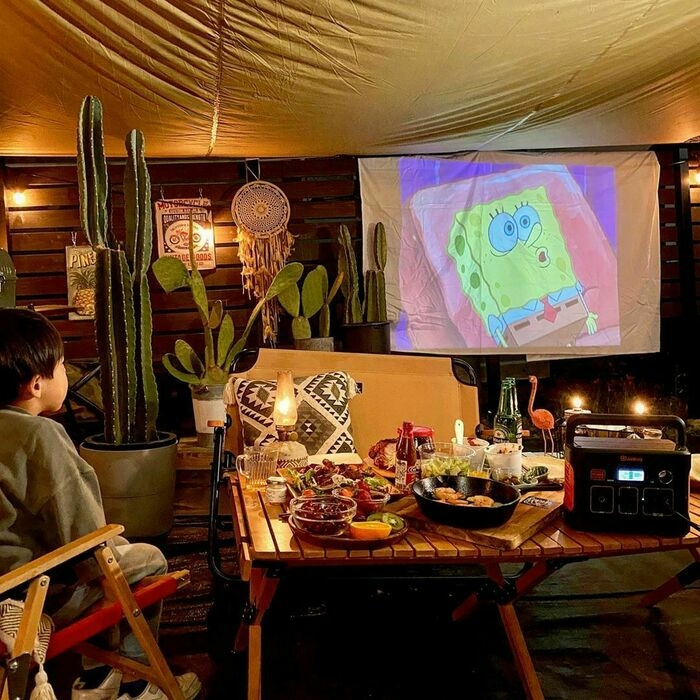 お庭キャンプで映画を見る子供