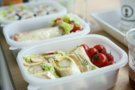ラップサンドやミニトマトが入った3つの白い弁当箱