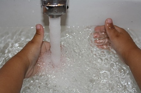 水道で水を貯めて手を洗う子どもの手