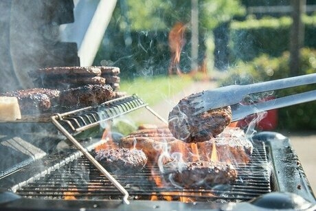 屋外のバーベキュー台で肉を焼いている