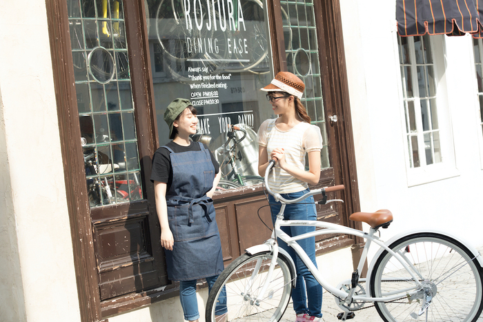 自転車店の前で談笑する店員と客
