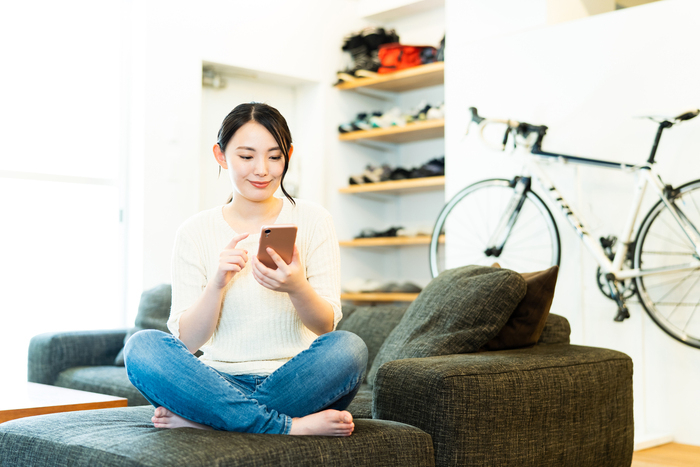 スマホを使ってネット検索をしている女性