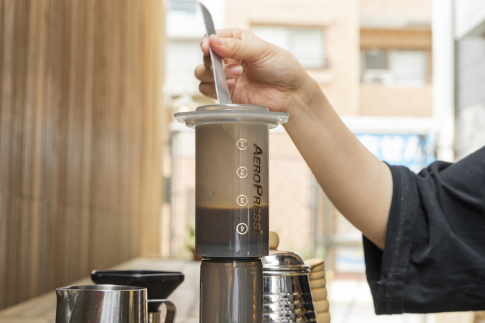 ヘラでコーヒーを混ぜる