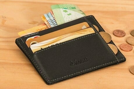 カードを収納した黒いカードケースからコインが数枚こぼれている