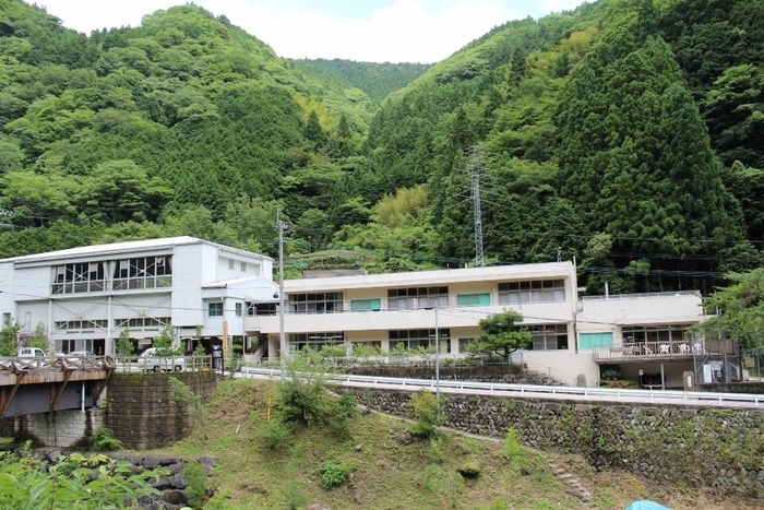 背後が山の2階建ての建物