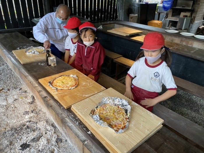 ピザ焼き体験をする小学生