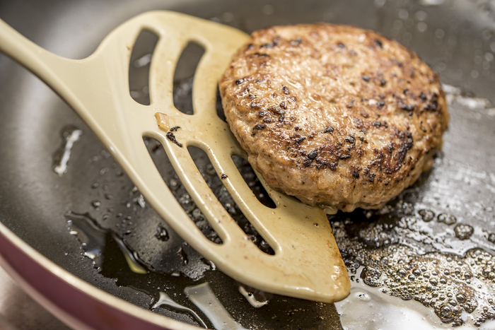 フライパンでハンバーグを焼く様子