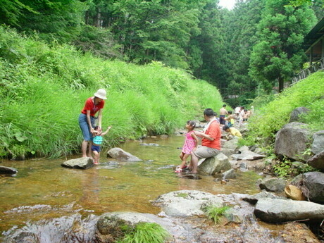 とよねランドオートキャンプ村に流れる川で遊んでいる家族の画像