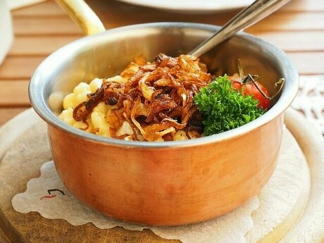 金属の小鍋に入った調理された麺や野菜