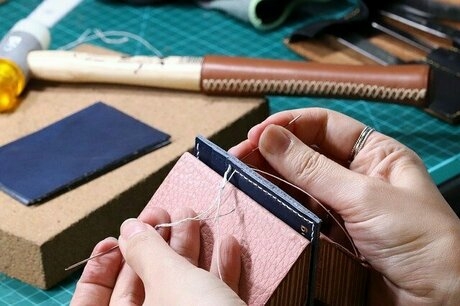 レザー素材に針と糸を通している