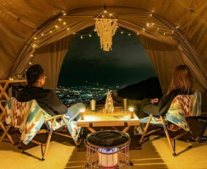 キャンプから夜景を眺めている夫婦