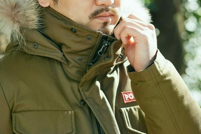 ダウンで暖をとる男性