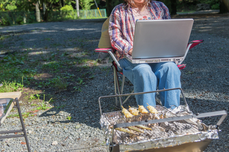 屋外でパソコンを使う人の画像