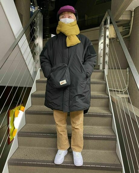 黄色のダウンマフラーを着けた女性