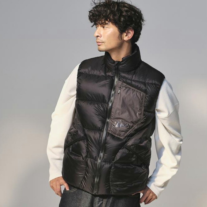白い服の上に黒いダウンベストを着た男性