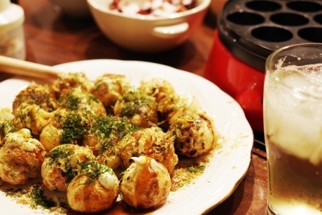 お皿に盛られたたこ焼きとグラスにはビール