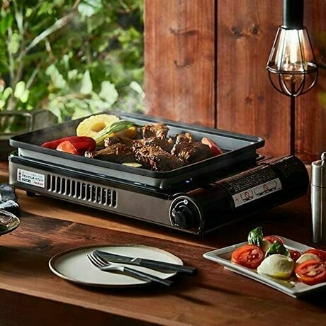 セッティングされたテーブルのホットプレートで焼かれている肉や野菜