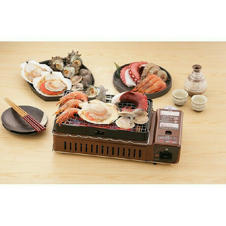 卓上カセットコンロだエビやホタテの海鮮を焼いている