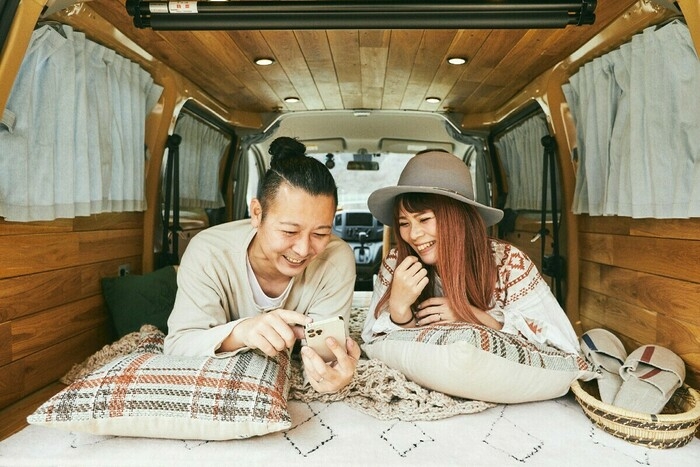 車内でどうがを見ながら笑いあう夫婦