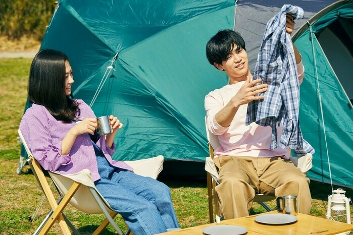 シャツを着てキャンプをしている男女
