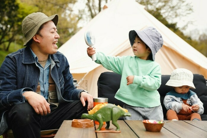 外でハンディファンを使う子ども