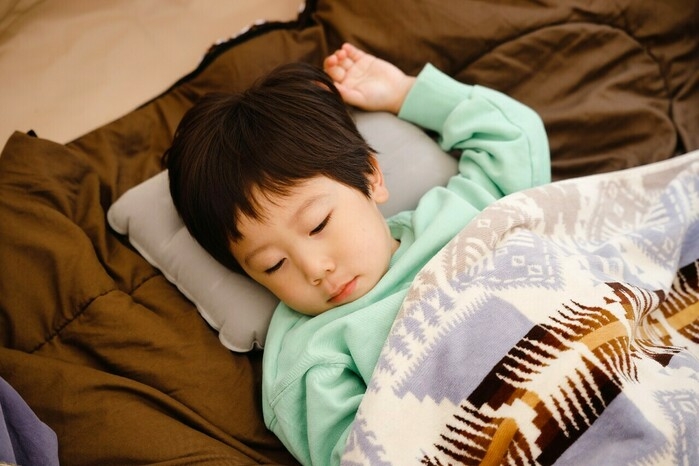 枕を使って眠る子ども