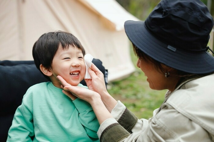 お母さんがビオレuの全身すっきりシートで子供を拭いている様子