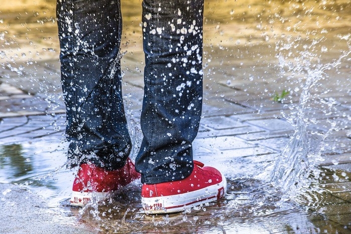 ALL STARを履いた人が水溜リ足を入れている写真