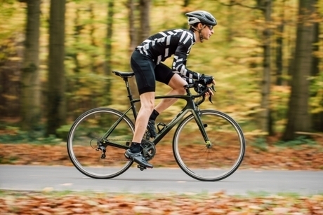 山道を自転車で走る男性