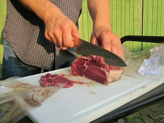 バーベキューで包丁で肉を切っているところ
