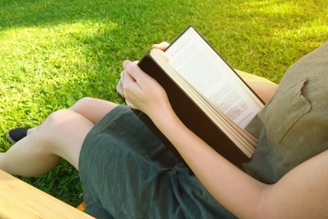 芝生で読書をする女性