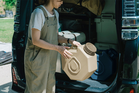 ウォータータンクを車に積む女性