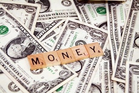 重ねられた1ドル紙幣とMONEYの文字