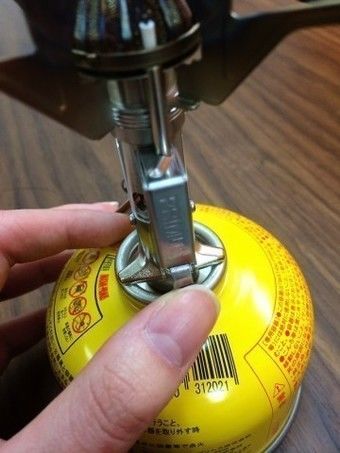 ガスカートリッジを支えながら点火する様子