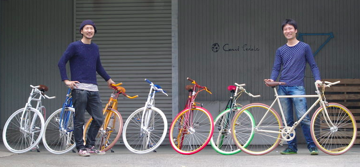 Cocci Pedaleのカラフルな自転車を持ち立つ男性