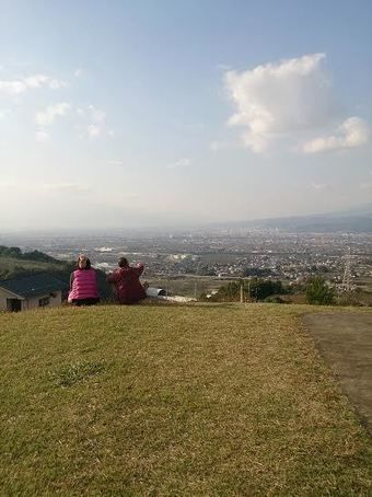 山梨県八代ふるさと公園の古墳から景色をみる人々