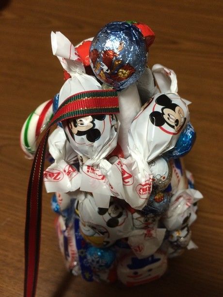 お菓子を貼り終わった土台にリボンを巻く途中の様子
