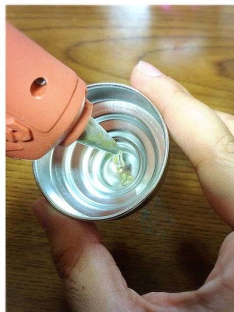 瓶のふたにグルーガンでグルーを流し込む様子