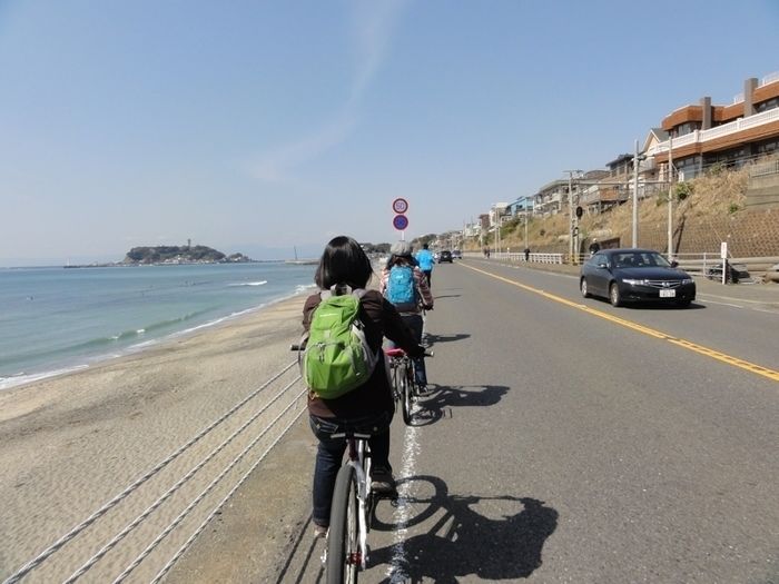 鎌倉ストリートサイクリングの海沿いをサイクリングする人の後ろ姿