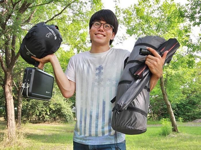 キャンプグッズを軽々と持つ男性