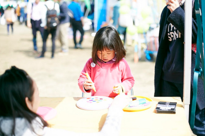 子供がフリスビーに絵を描いている様子