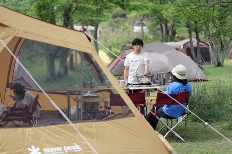 スノーピークのキャンプギアでキャンプを楽しむ人々