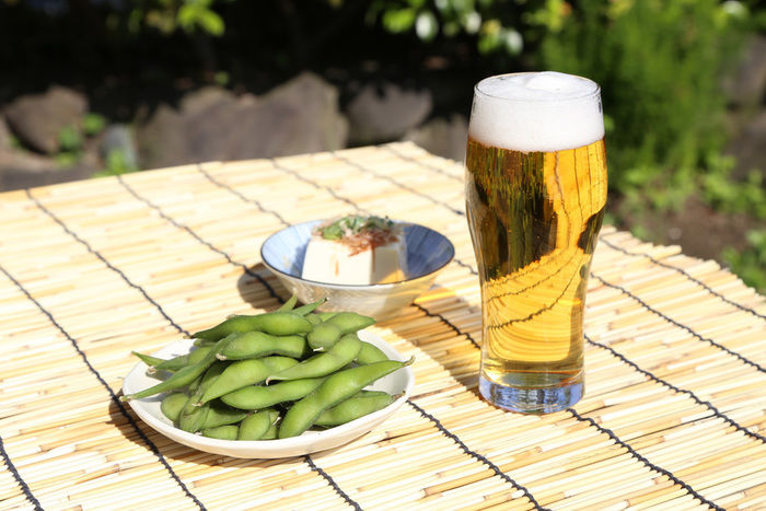 机に並べられたビールと冷奴と枝豆